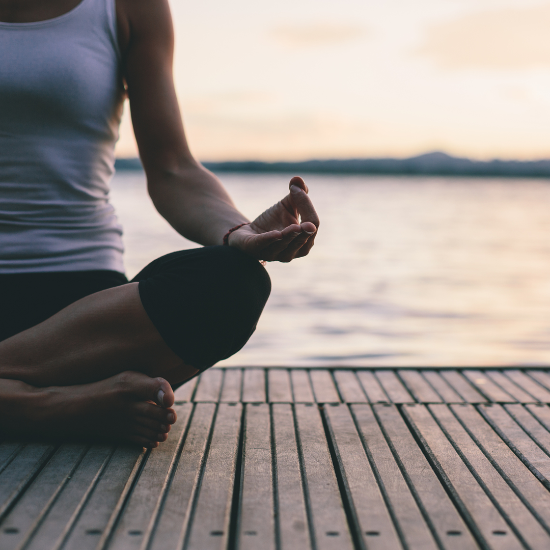 Kobieta medytuje na pomoście jako element codziennej rutyny self-care